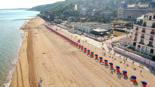 Hôtel de la Plage في أولغات: اطلالة جوية على شاطئ مع مظلات