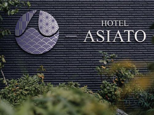 Tabist Hotel Asiato Namba في أوساكا: علامة الفندق على جدار أسود