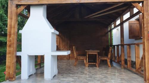 een veranda van een huis met een tafel en stoelen bij Rustic House Busteni in Buşteni