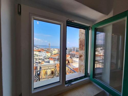 una camera con tre finestre con vista sulla città di Gythio townhouse a Gythio