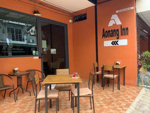 um grupo de mesas e cadeiras num restaurante em Aonang Inn em Cidade de Krabi