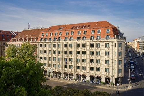 un gran edificio blanco con techo rojo en Hotel Luc, Autograph Collection en Berlín