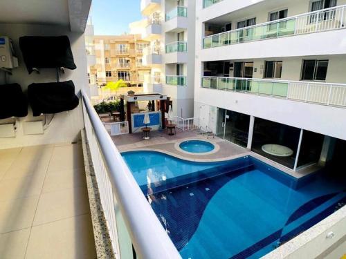 un edificio de apartamentos con una gran piscina en el balcón en Manfrenati Ap, en Cabo Frío