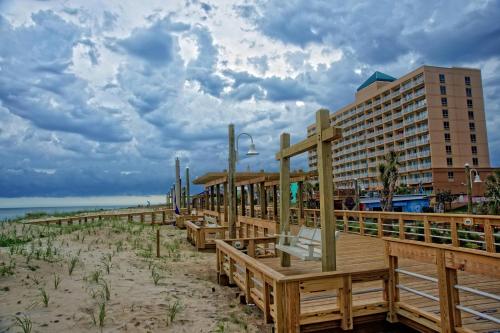 un complejo en la playa con bancos y un edificio en Courtyard Carolina Beach, en Carolina Beach