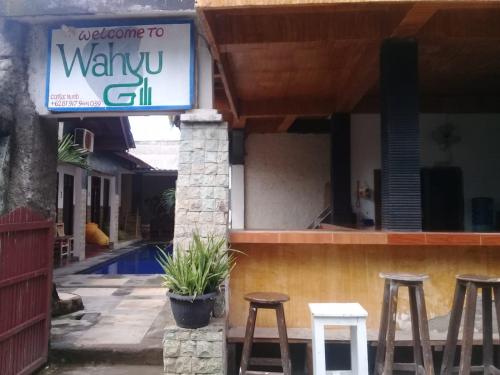 un cartello per un ristorante con sgabelli davanti di Wahyu Gili 1 a Gili Trawangan