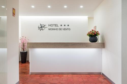 un cartello per un hotel con fiori su un muro di Hotel Moinho De Vento a Viseu