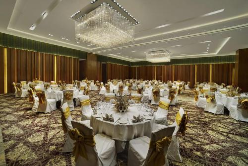 een grote feestzaal met witte tafels en stoelen bij Hyatt Regency Amritsar in Amritsar