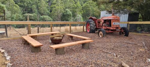 ein alter Traktor und Bänke vor einem LKW in der Unterkunft Wally's Edge 20acre Farm Stay in Rawson