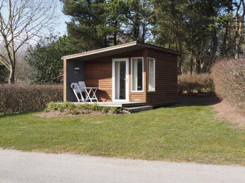 Cabaña pequeña con silla en el césped en First Camp Aarhus - Jylland, en Aarhus