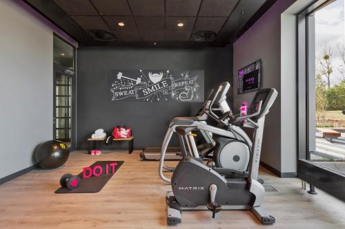 sala de fitness con cinta de correr y gimnasio en Moxy Katowice Airport, en Pyrzowice