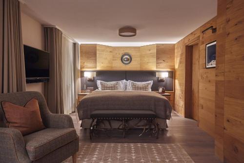 ein Schlafzimmer mit einem Bett, einem Sofa und einem Stuhl in der Unterkunft The Capra Saas-Fee in Saas-Fee