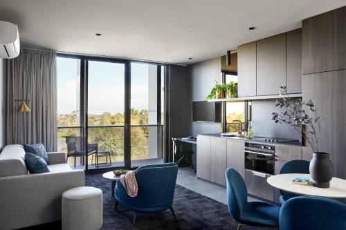 a living room with a couch and a table and chairs at Punthill Caroline Springs in Caroline Springs