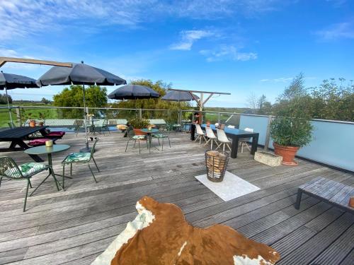 een terras met stoelen, tafels en parasols bij Valerius Boutique Hotel in Wormer