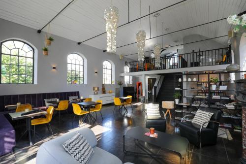 een grote kamer met stoelen en tafels en een trap bij Valerius Boutique Hotel in Wormer