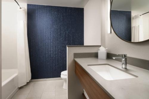 a bathroom with a sink and a mirror at Fairfield Inn & Suites by Marriott South Kingstown Newport Area in South Kingstown