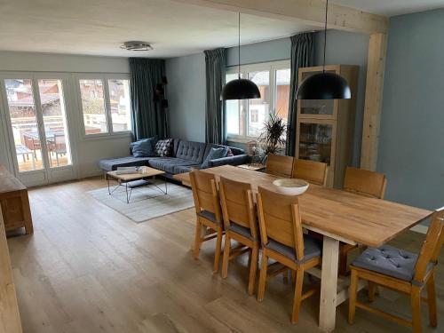 a living room with a wooden table and chairs at Spring Inn Apartments in Meiringen