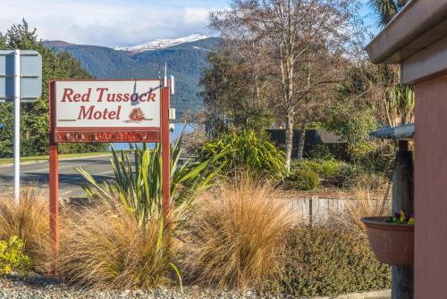 un cartello rosso di un motel di fronte a un edificio di Red Tussock Motel a Te Anau