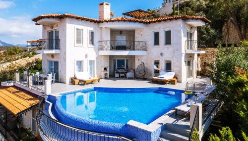 eine Villa mit einem Pool vor einem Haus in der Unterkunft Villa Mavi Manzara in Kaş