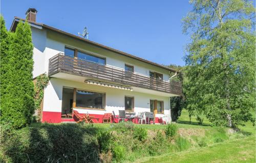 ein Haus mit roten Tischen und Stühlen davor in der Unterkunft Gorgeous Apartment In Lenzkirch-Saig With Kitchen in Lenzkirch