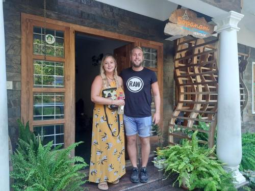 a man and a woman standing in front of a house at Sopanam Heritage Thekkady in Thekkady