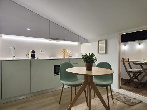 una cucina con tavolo e sedie in una stanza di Wood Essence Apartment - Cozy Balcony a Coimbra