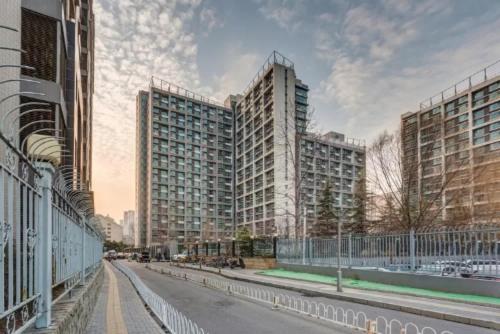 una strada vuota con edifici alti in una città di Beijing Yasmine Seasons Park Apartment Hotel a Pechino