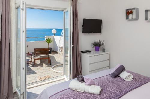 a bedroom with a bed and a view of the ocean at Sky Way Apartments in Dugi Rat