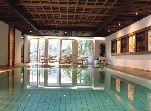 una piscina con tavoli e sedie in una casa di Hotel Sittnerhof a Merano