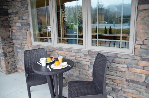 - une table et deux chaises sur une terrasse couverte avec une table et de la nourriture dans l'établissement Stonebrook Lodge, à Cherokee