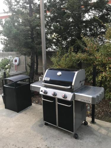 a barbecue grill with a bench in a backyard at Courtyard Novato Marin/Sonoma in Novato