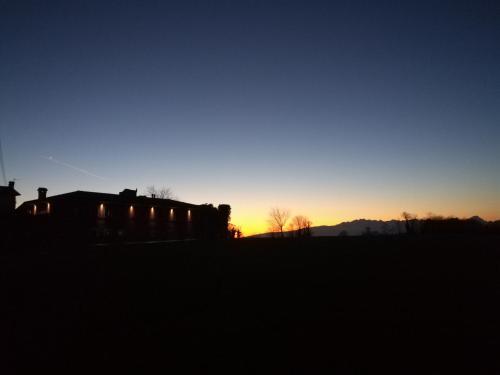 a silhouette of a house with the sunset in the background at Falco Bianco in San Daniele del Friuli