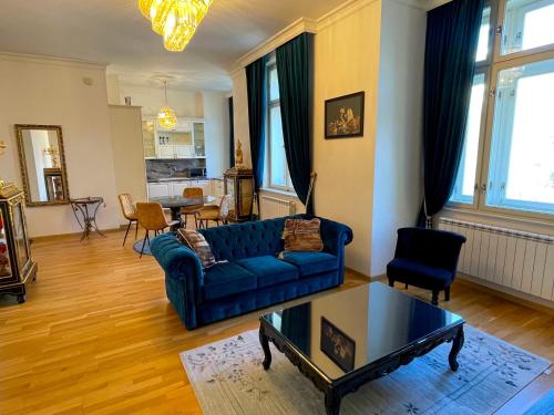 uma sala de estar com um sofá azul e uma mesa em Karlsbad Prestige em Karlovy Vary