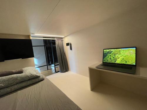 Pokój z łóżkiem i telewizorem na ścianie w obiekcie Sleep&Go Hostel Ljubljana w Lublanie