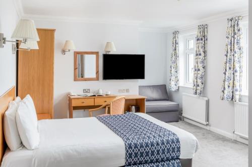 een hotelkamer met een bed, een bureau en een stoel bij The Kilbirnie Hotel in Newquay