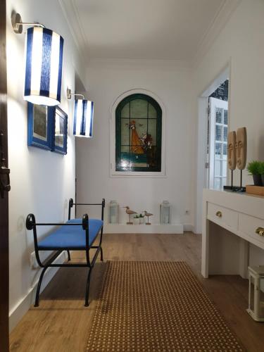 a room with a chair and a stained glass window at Casa "Vó Minda" - Nazaré - Alojamento Local in Nazaré