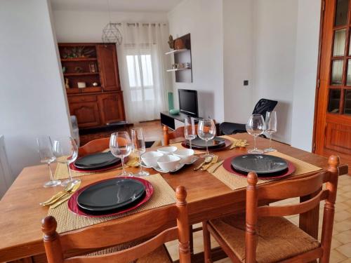 una mesa de madera con copas de vino y platos en ella en Modern & Cosy Apartment in Fundão Centre, en Fundão