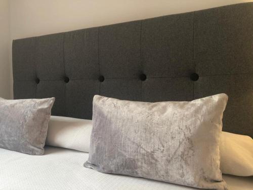 a bed with a brown headboard and two pillows at Sevilla Aljarafe Room in Bormujos