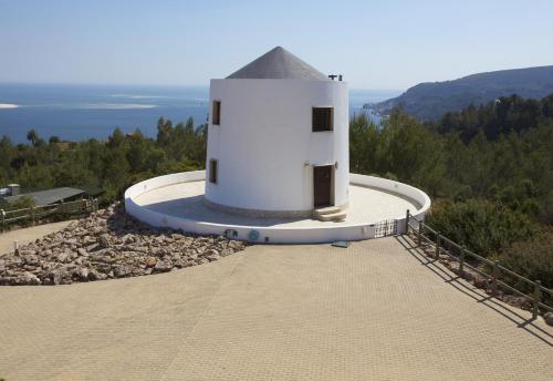 een gebouw op de top van een heuvel met de oceaan bij Quinta Dos Moinhos De Sao Filipe in Setúbal