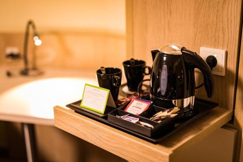 - une cafetière noire sur un plateau dans l'établissement First Inn Hotel Zwickau, à Zwickau