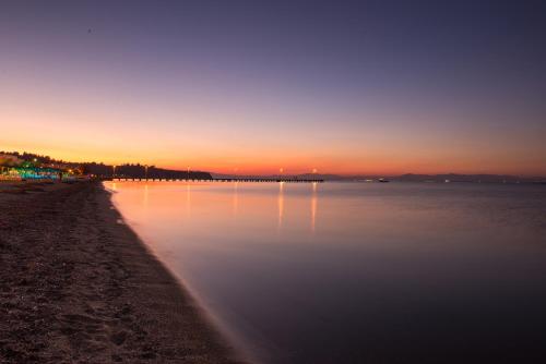 zachód słońca nad wodą z plażą w obiekcie Hotel Pithari w mieście Agia Triada