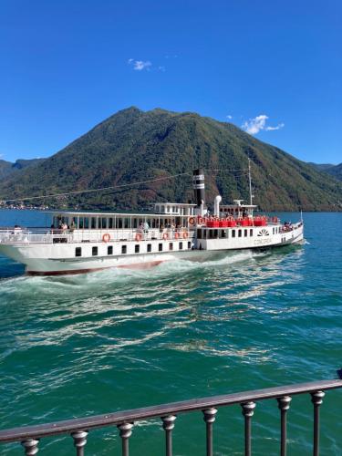 a boat on the water with a mountain in the background at Casa Lisa in Lenno