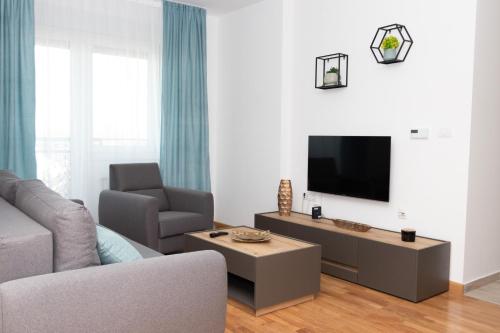 Televízia a/alebo spoločenská miestnosť v ubytovaní Millennium Apartment