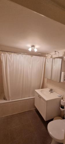 a bathroom with a white shower curtain and a sink at Alliance Hotel Ieper Centrum in Ypres