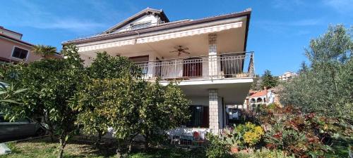 a large white house with a balcony and trees at Apartmaji Ri-100 in Portorož