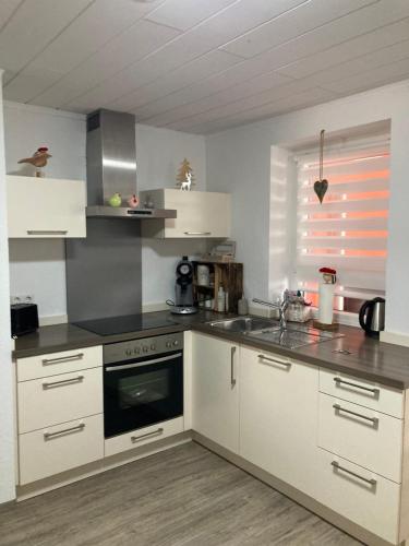 a kitchen with white cabinets and a stove top oven at Ferienwohnung Petra in Rust