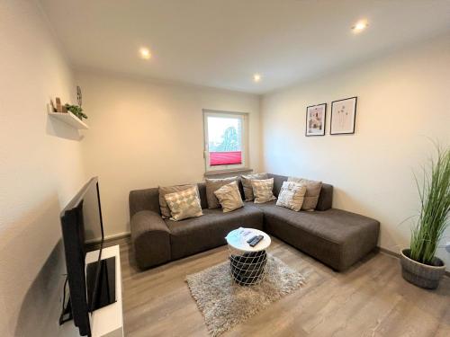 a living room with a couch and a flat screen tv at City Apartment Ochtrup - NETFLIX - WALLBOX in Ochtrup