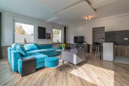 uma sala de estar com um sofá azul e uma cozinha em Gemütliches Apartment in Neuwied em Neuwied