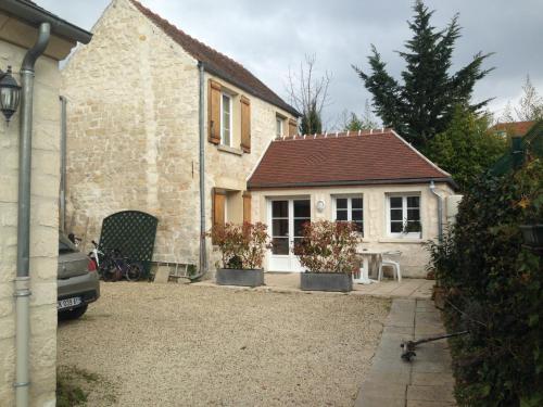 a house with a table in front of it at Gîte Les Rainettes in Coye-la-Forêt