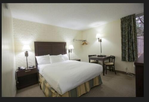 a hotel room with a large bed and a desk at Inns of Virginia Arlington in Arlington