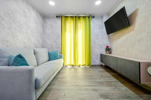 uma sala de estar com um sofá e uma cortina amarela em Apartments Lilia Reus em Reus